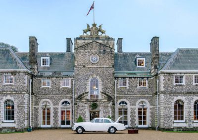 Photo of the front of Farleigh Wallop with a Bentley outside